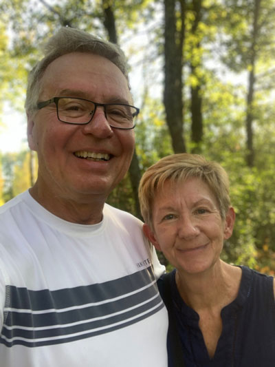 Veda Kanitz with her husband standing infront of a wooded area