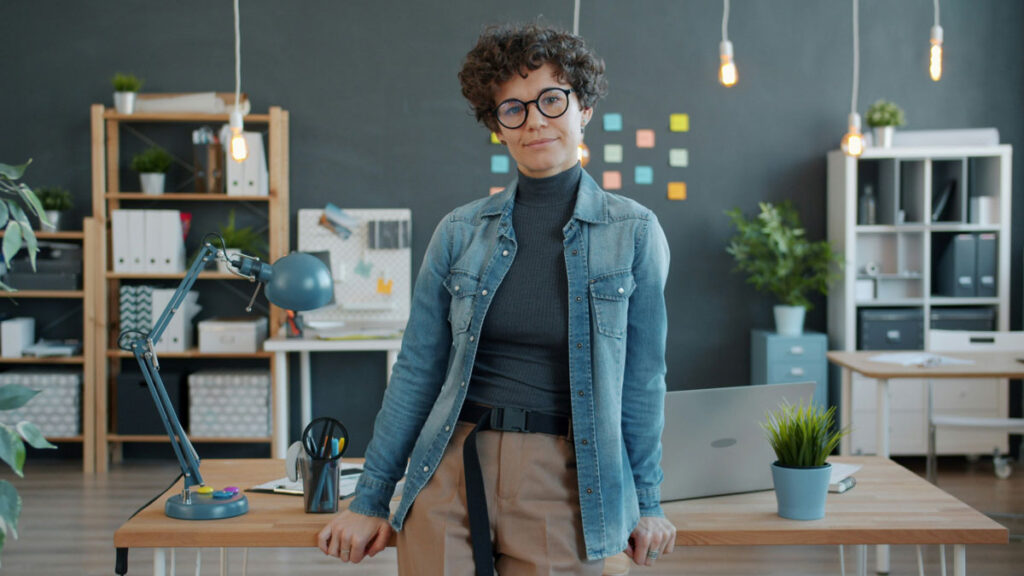 Middle age woman standing in front of a desk in a workplace. Photo by Vitaly Gariev on Unsplash
